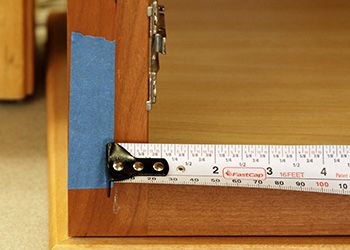 Measure from the edge of your tape mark to the cabinet opening. Measure from the edge of your tape mark to the cabinet opening.